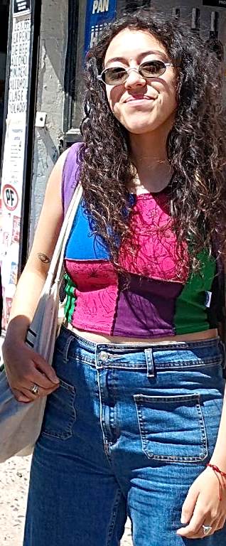 Une femme debout aux cheveux longs en t-shirt et jean.