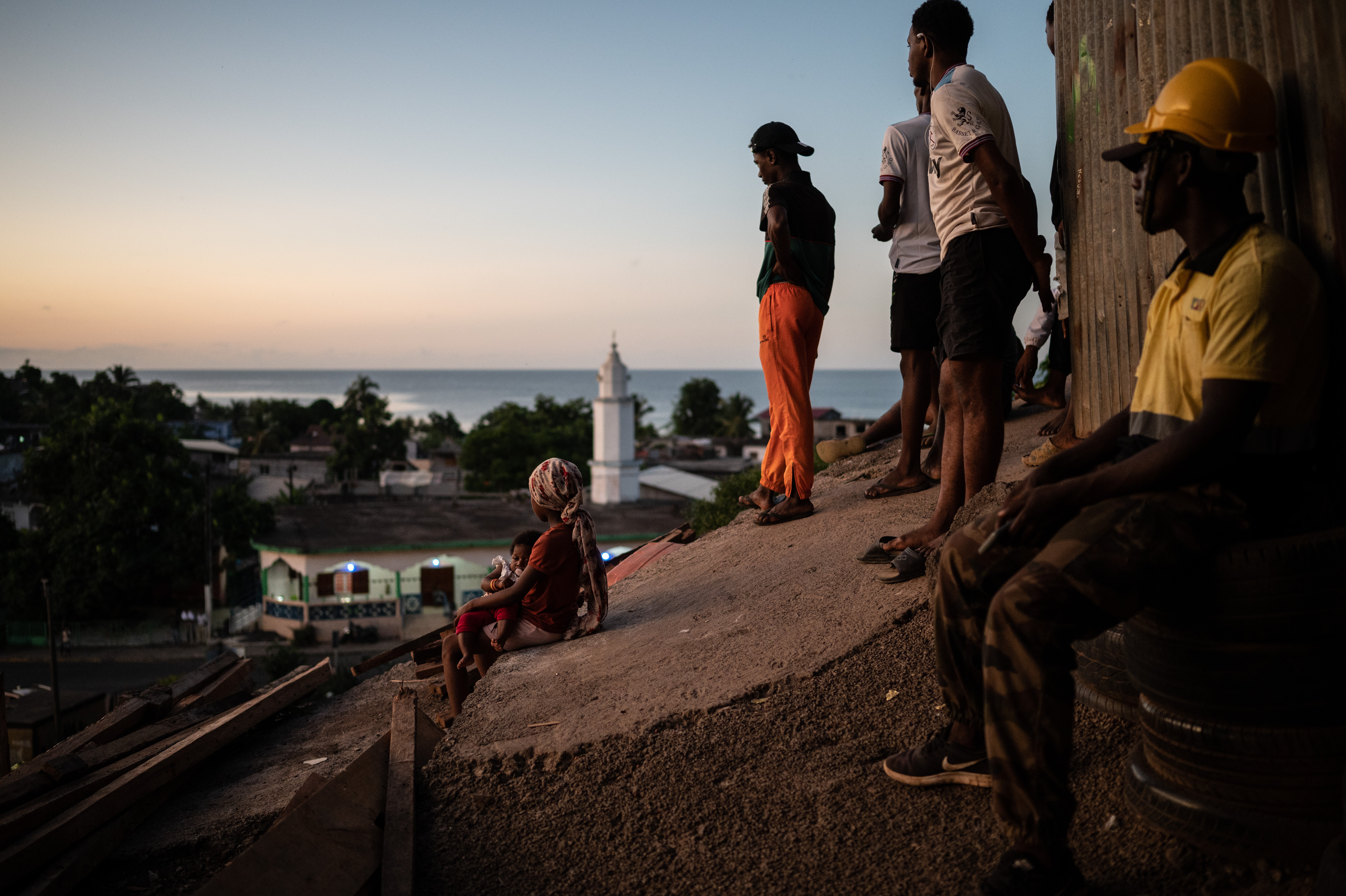 Des habitants d'un quartier populaire sur une colline de Koungou regardent la mer