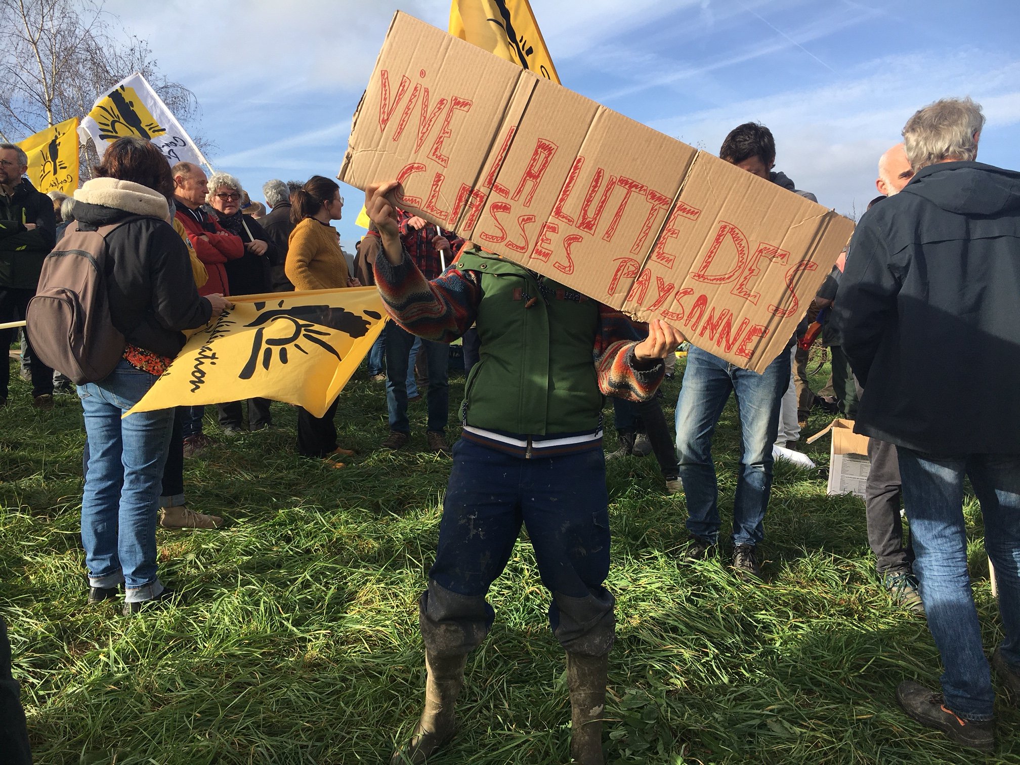 Une paysanne tient une pancarte "vive la lutte des classes paysanne"