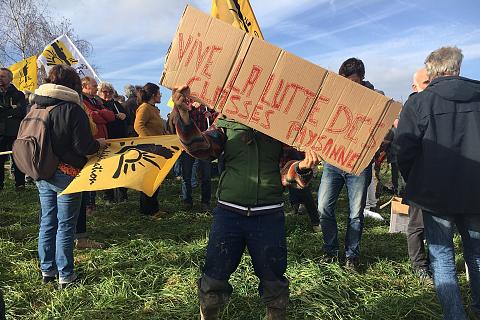 Une paysanne tient une pancarte "vive la lutte des classes paysanne"