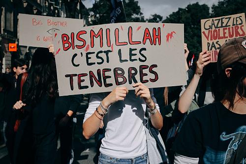 Une personne tient une pancarte "Bismillah c'est les ténèbres" et se cache le visage. Des lycéens, étudiants, personnels de l'éducation et des soutiens syndicaux participent à une manifestation à Bordeaux, en Gironde, le 13 octobre 2026.