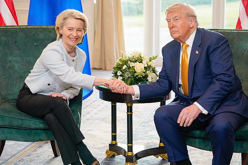 Ursula von der Leyen et Donald Trump, assis, se serrent la mains. Ursula von der Leyen sourit, pas Donald Trump. 
