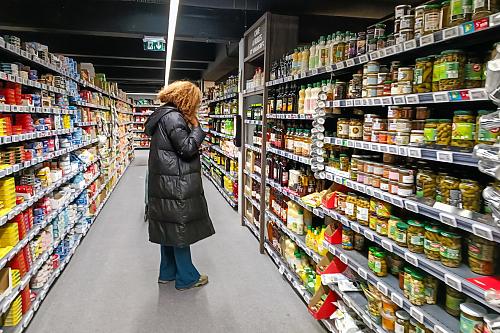 Une femme devant un rayon de supermarché