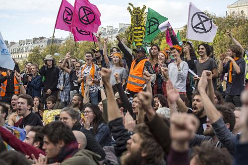 des militant·es de extinction rebellion (XR) avec des drapeaux