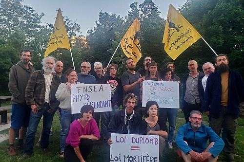 des femmes et hommes tiennent des panneaux "loi duplomb-loi mortifère", 'fnsea phytodépendant" avec des drapeaux de la Confédération paysanne