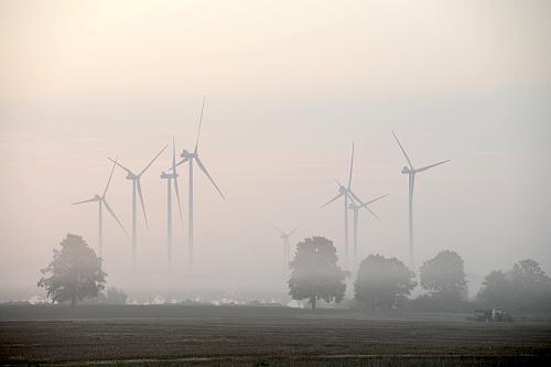 Sept éoliennes dans la brume. 