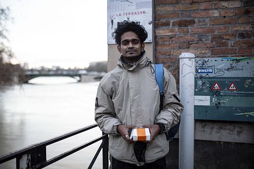 un jeune homme debout souriant près d'un canal