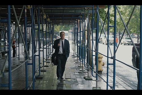 un homme en costume cravate marche dans une rue aux Etats Unis