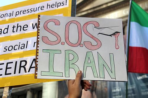une main tient la pancarte SOS Iran