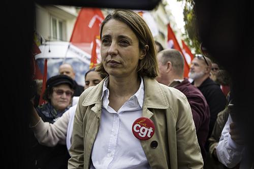 Sophie Binet, secrétaire générale de la CGT est vêtue d'une chemise blanche, une veste grise et port un badge CGT.