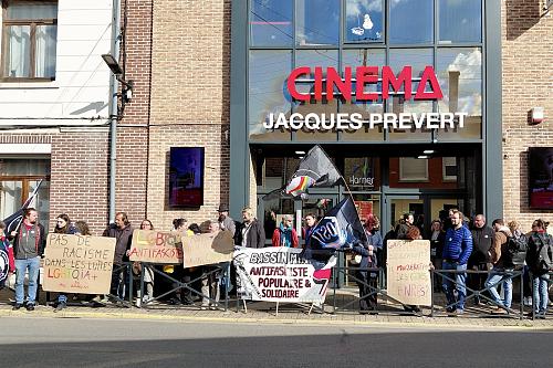 Des manifestants devant un cinéma, portant des pancartes contre les LGBTphobies et le maire RN de Harnes