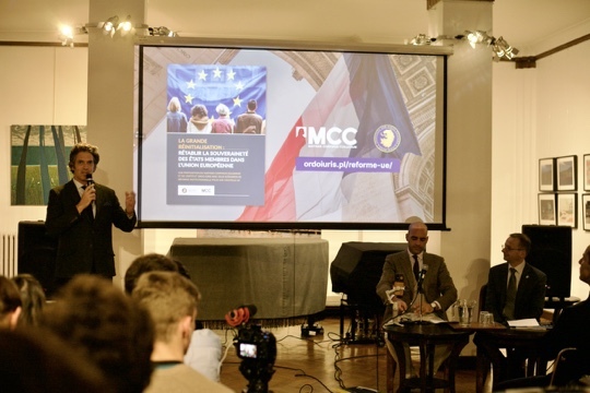 Un homme au micro devant la salle