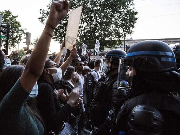Des manifestantes et manifestants face à des policiers casqués.