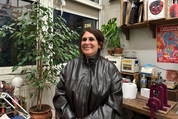 Sophe souriante dans une pièce encombrée. 