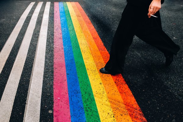 Une personne marchant sur les couleurs LGBTQI+ peintes au sol