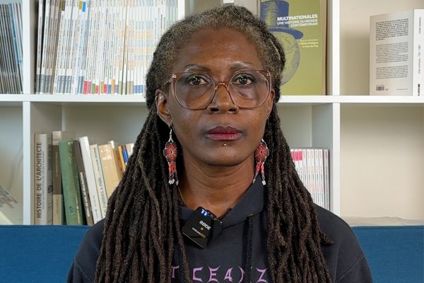 portrait de Fatou Dieng, devant une bibliothèque 