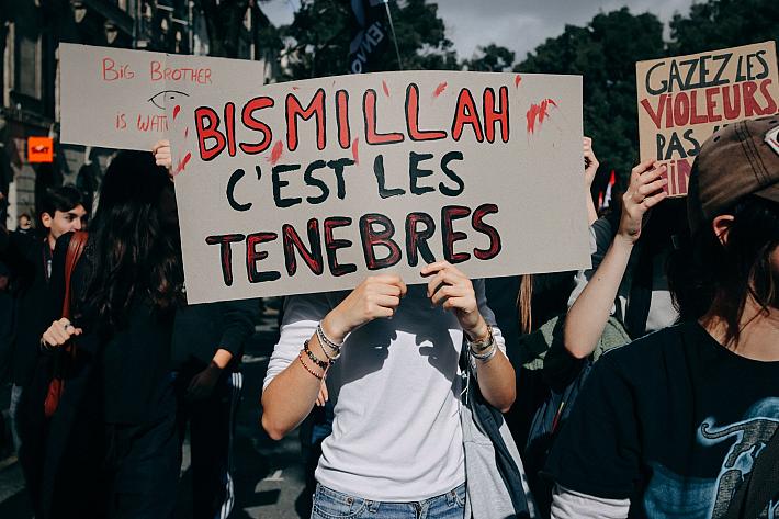 Une personne tient une pancarte "Bismillah c'est les ténèbres" et se cache le visage. Des lycéens, étudiants, personnels de l'éducation et des soutiens syndicaux participent à une manifestation à Bordeaux, en Gironde, le 13 octobre 2026.