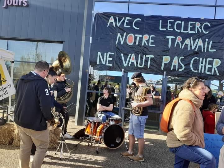 Une banderole "Avec Leclerc notre travail ne vaut pas cher" est déployée devant l'entrée d'un hypermarché.
