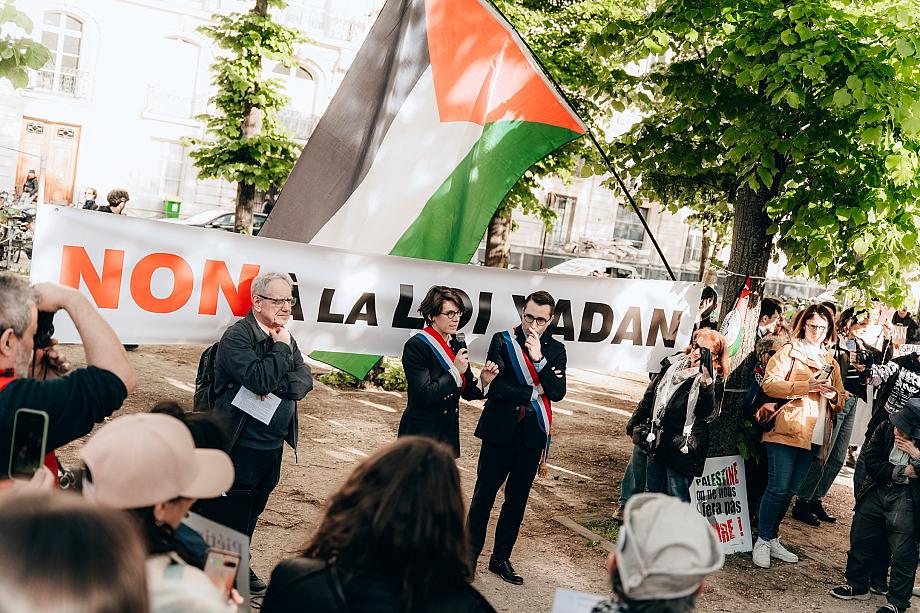 Une banderole "Non à la loi Yadan" déployée devant quelques dizaines de personnes