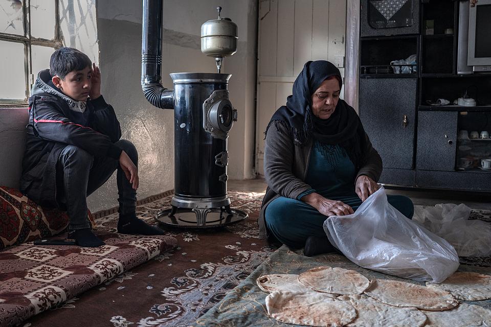 Muxafa et son fils dans l'austère salon de leur logement.