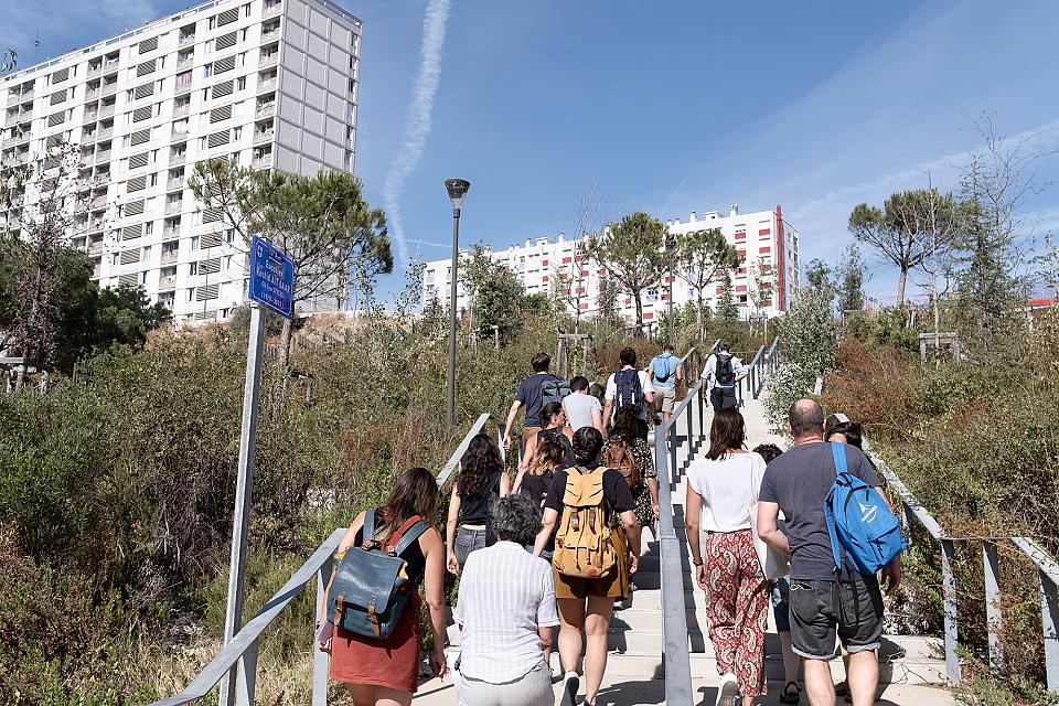 Un groupe de femmes et d'hommes montent des escaliers dans le 13ème arrondissement de Marseille