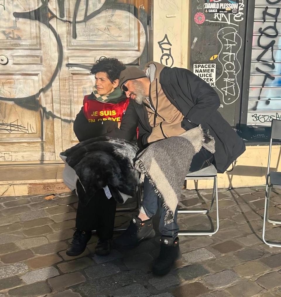Deux personnes assises sur des chaises pliantes, un homme et une femme.
