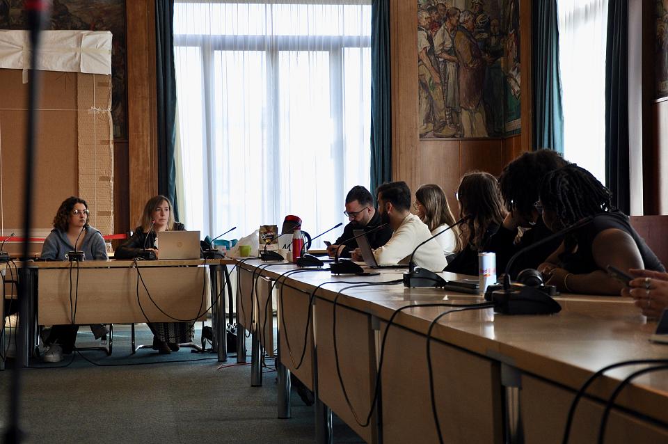 Des jeunes autour d'une table devant des micros.