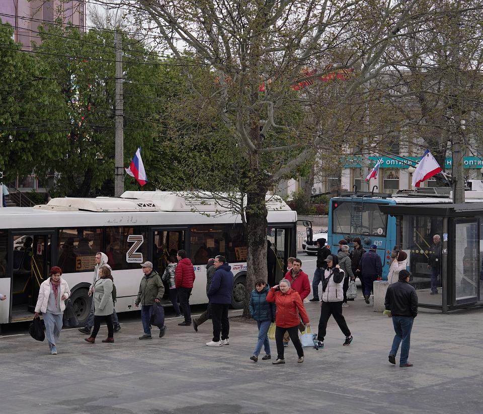 Bus avec un « Z » sur les vitres, dans une rue animée. 