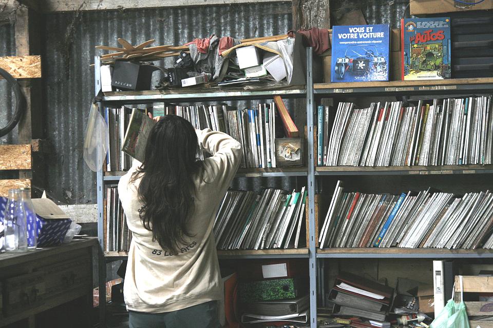 Une femme de dos devant une bibliothèque 