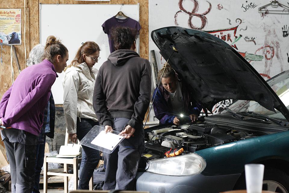 Quatre femmes autour d'un capot de voiture ouvert 