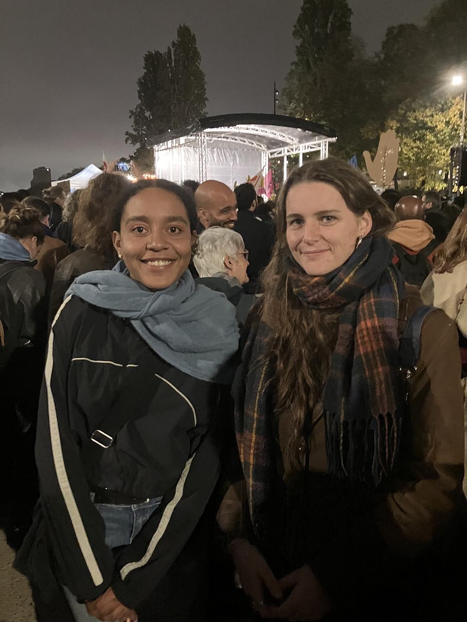 Deux jeunes femmes regardent l'objectif au milieu du rassemblement.