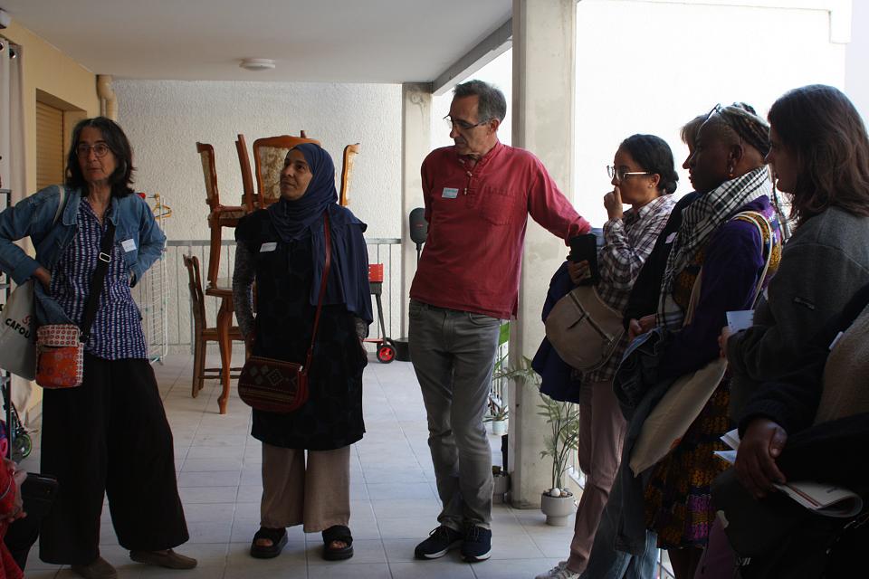 Six personnes debout sur une terrasse discutent.