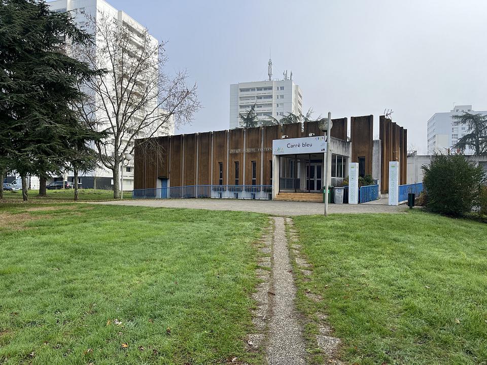 Un bâtiment, au milieu des tours, où l'on accède par un petit chemin tracé dans l'herbe