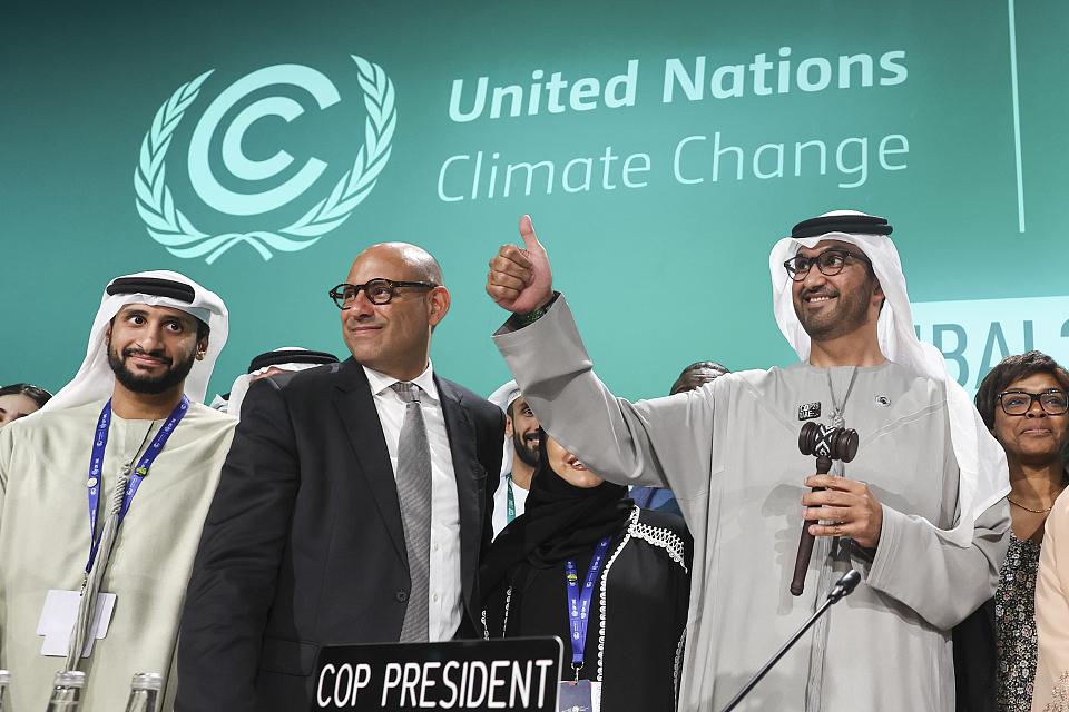 Des hommes sourient lors d'une déclaration officielle à la Cop28. 