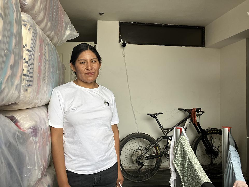 Daysi Huanca en jean et tshirt blanc devant un vélo.
