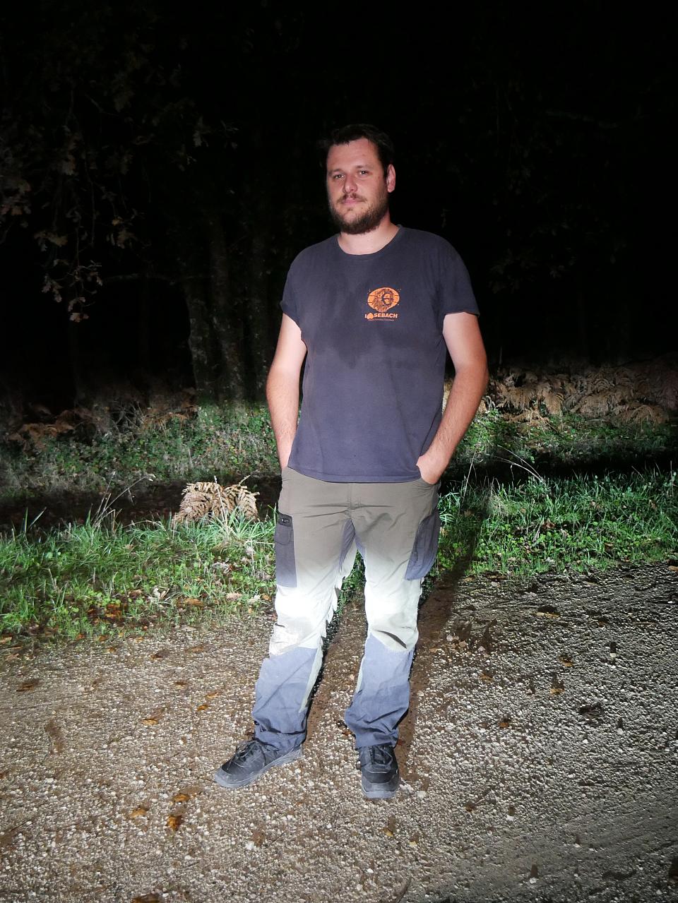 Un homme debout dans la forêt, de nuit
