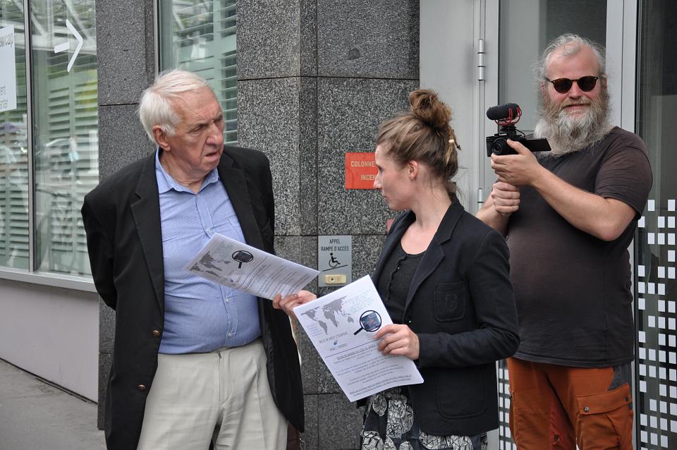 Un homme en costume parle à deux personnes