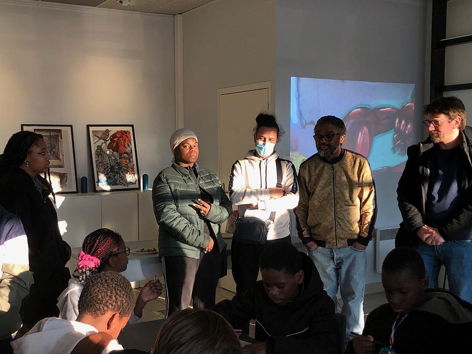 Un groupe de jeunes devant des photos 