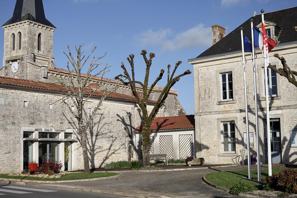 La mairie de Lairoux et sa salle communale, arborant la devise "Liberté, égalité, fraternité". Derrière, une église.