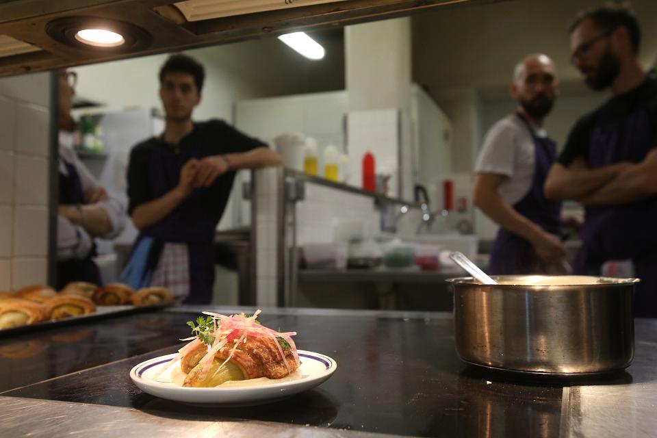 Un plant soigné au premier plan, quatre personnes au second plan.