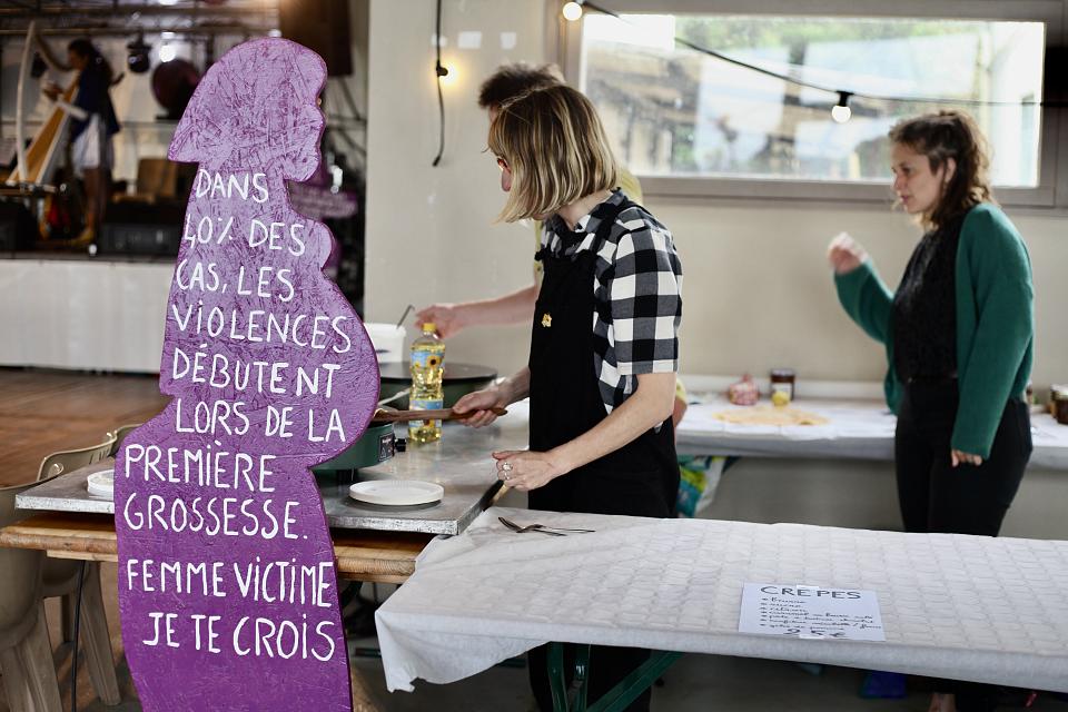 Trois perosnnes font des crêpes sur un stand. 