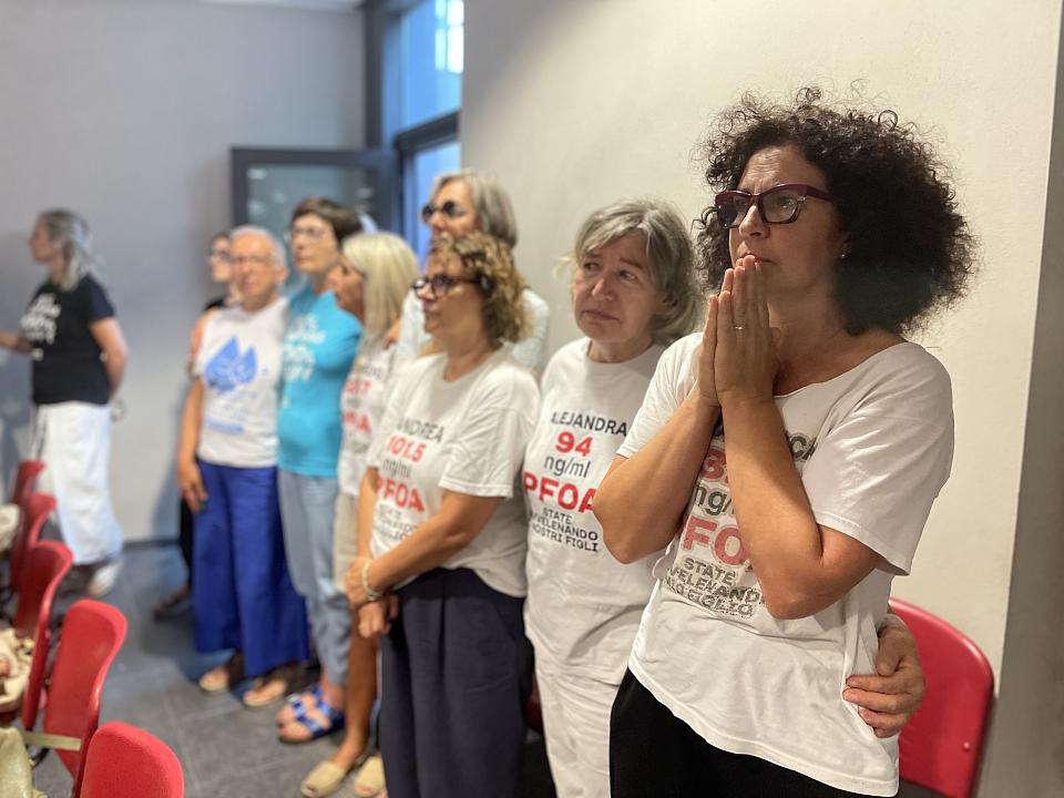 des femmes arborant des T-shirt avec le taux de PFOA dans une salle d'audience