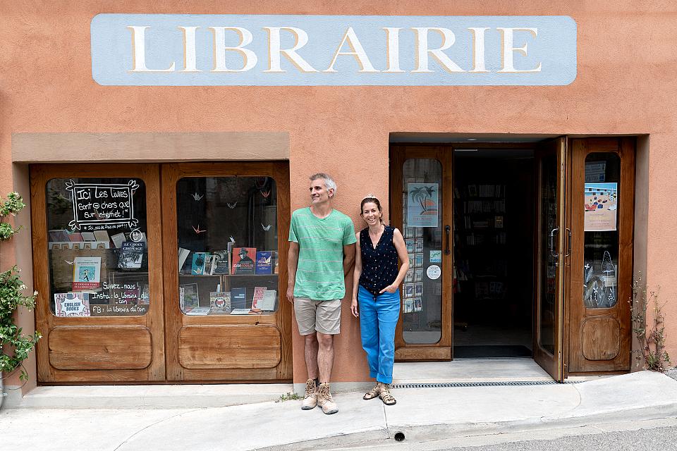 Les deux libraires devant la devanture de leur librairie.