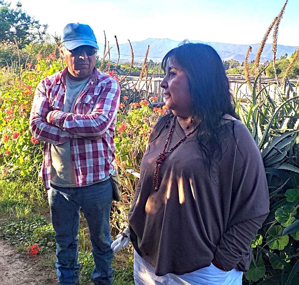 Un homme et une femme devant une haie. 