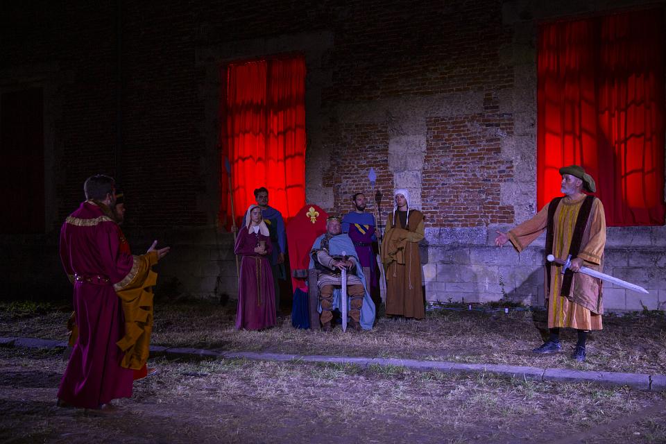 Des comédiens en habit médiéval, avec au centre un roi et son épée