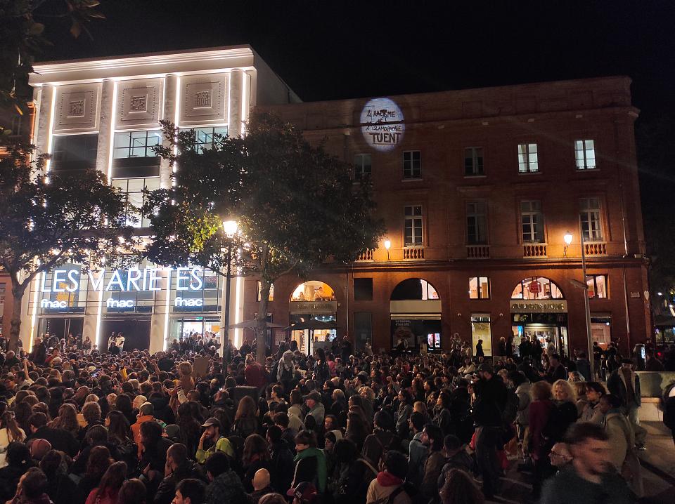 Des manifestants dans la nuit sur une place devant le théâtre des Variétés de Toulouse.