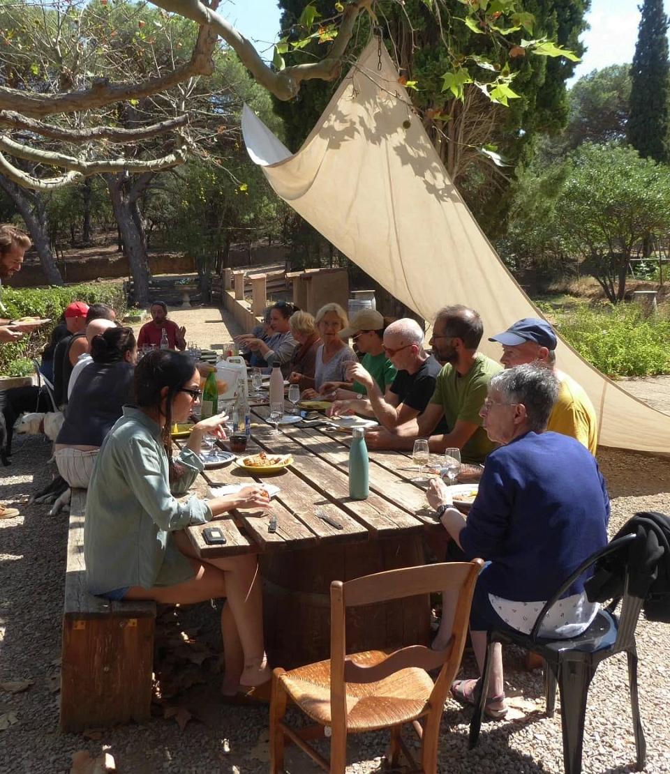 des femmes et hommes sont réunis autour d'une table et échangent