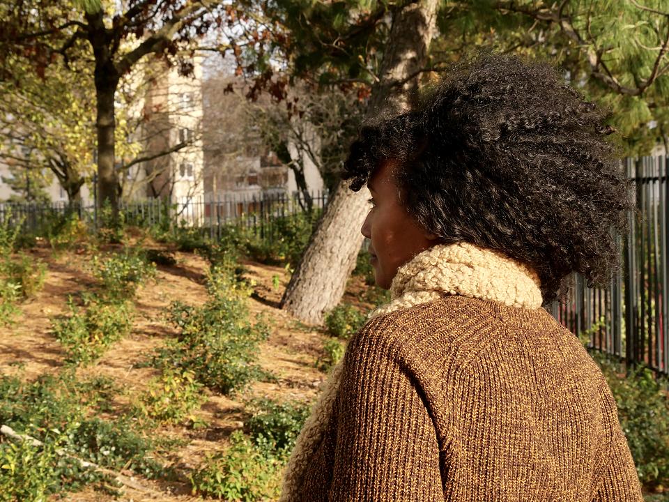 Une femme, de dos, dans un parc.