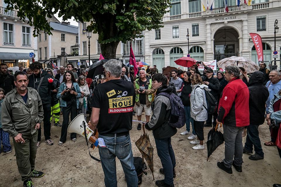 Au premier plan, devant une quarantaine de personnes, un manifestant avec un tee-shirt "Bloquons tout, indignons-nous"t