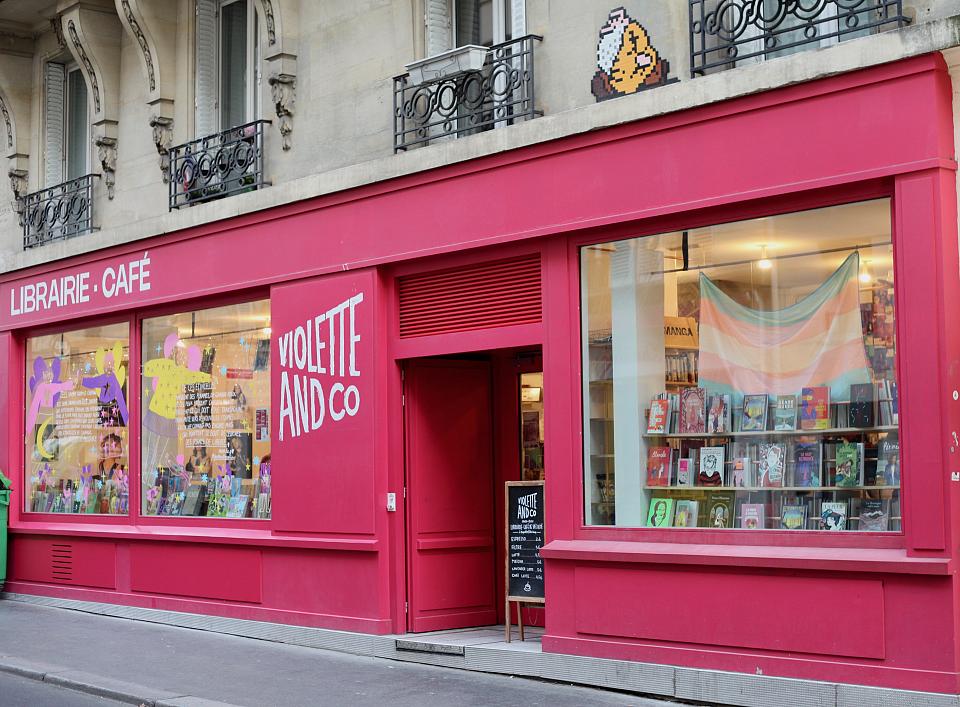 Devanture d'une libriaire, vue de la rue. La devanture est peinte en rose. 